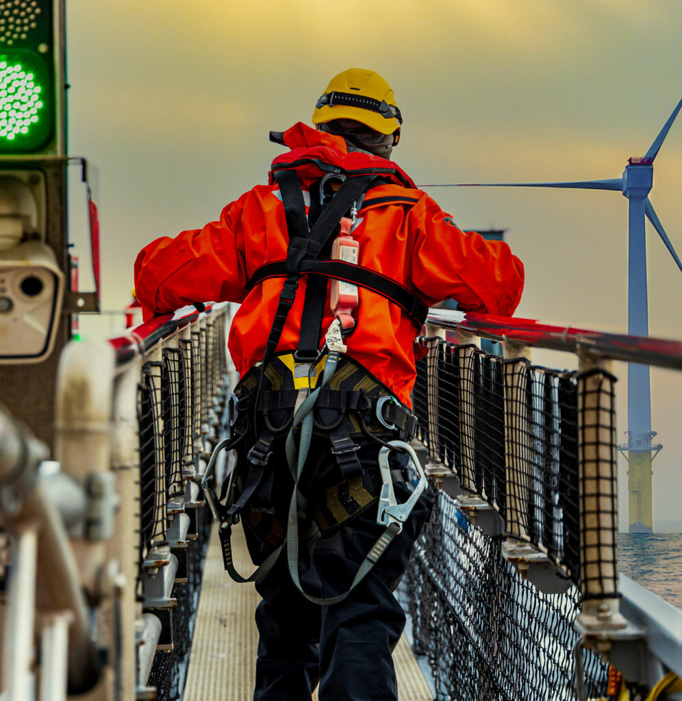 Man walking down a aisle in rigging gear.